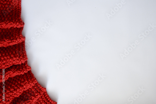 Knitted red blanket on a wooden background with copy space