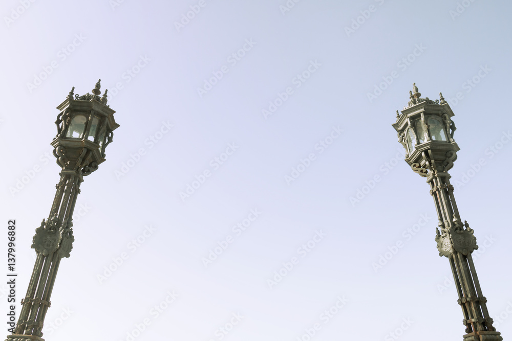 Fototapeta premium Streetlight isolated. Wrought iron lanterns with blue sky background