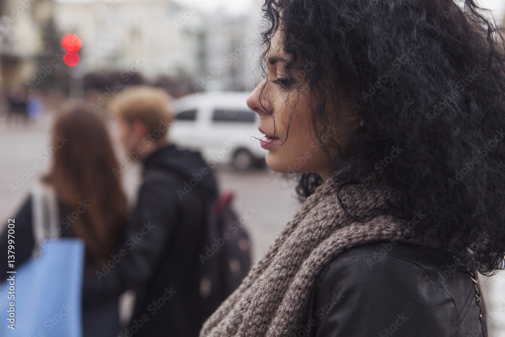 Beautifil brunette caucasian woman in leather jacket and scarf walking on european city in evening. cold weather. copy space Beautifil brunette caucasian woman in leather jacket and scarf walking on european city in evening. cold weather. copy space