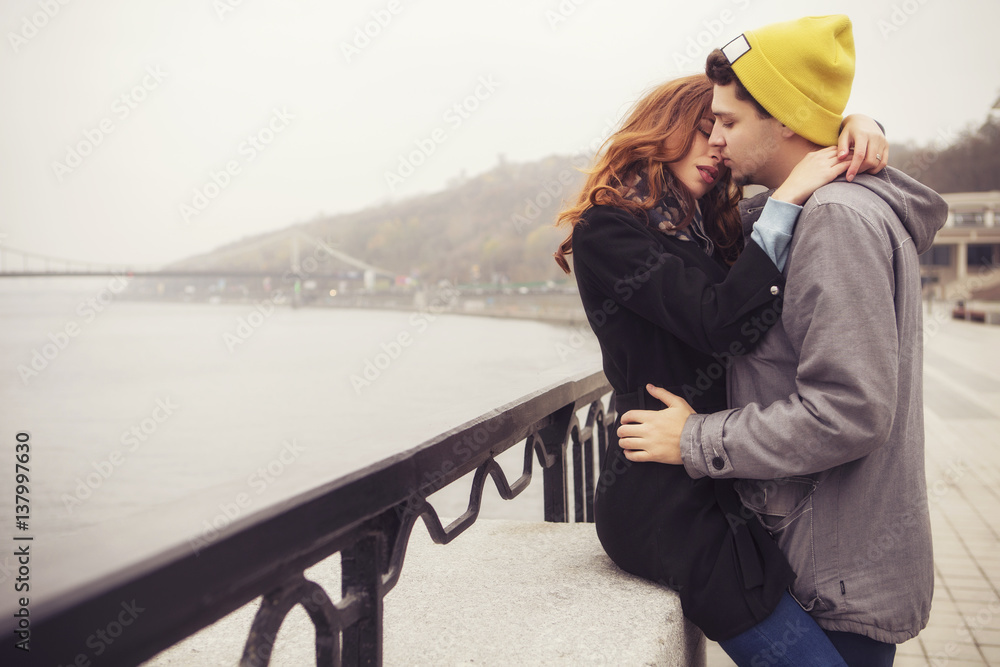 Cute brunette loving couple on a date. cold autumn, winter or spring day, european city. copy space