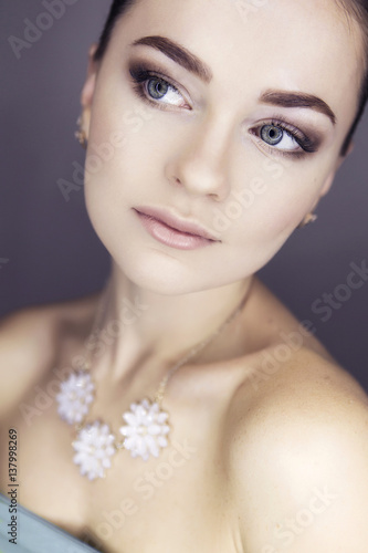 Beautiful brunette bride model woman in white necklace and with wedding delicate make up. Looking sideways (up). Soft focus. Clean fresh skin