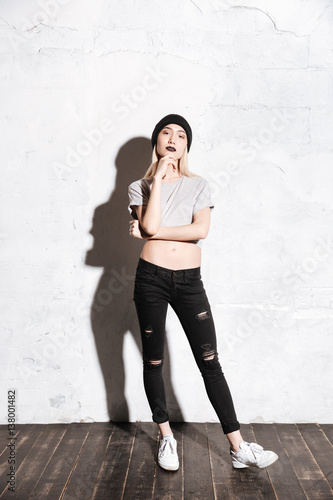 Full length of woman in black hat and torn jeans