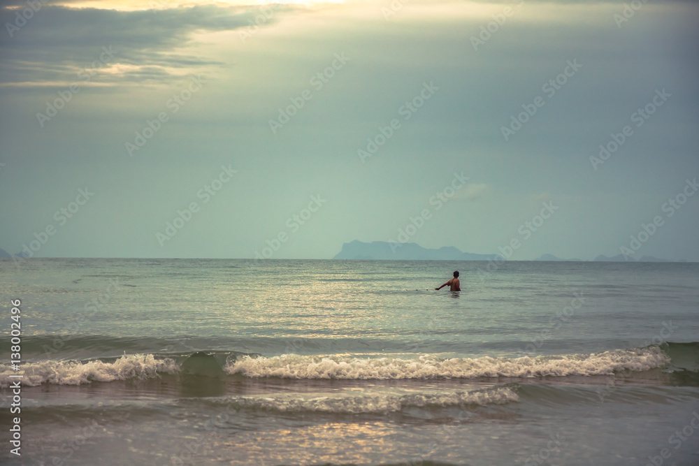 Fototapeta premium One man in the sea fishing during sunset with scenic sea view
