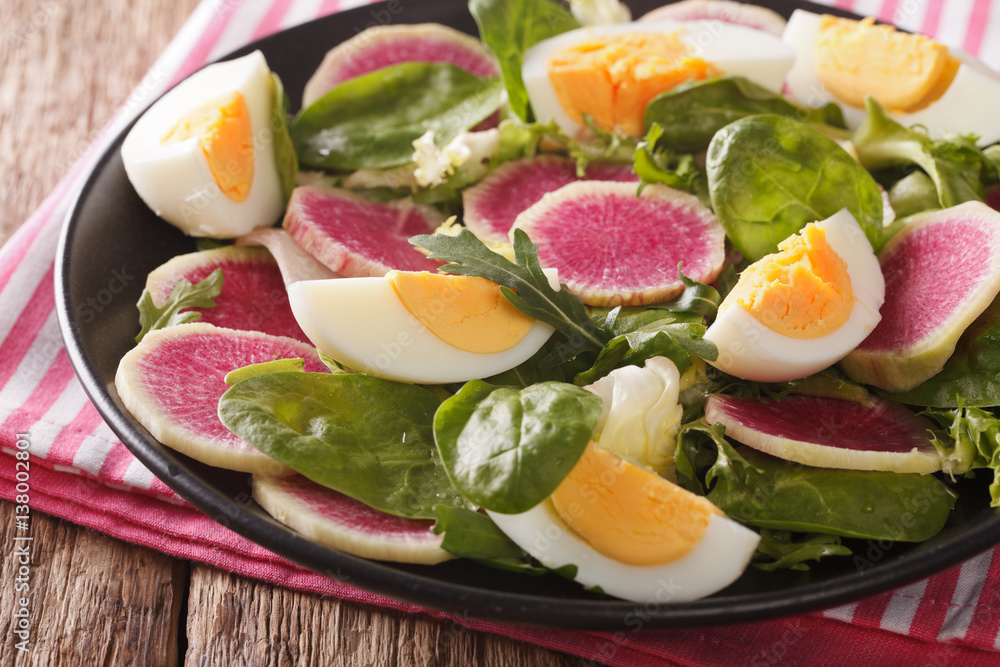 salad of watermelon radishes, eggs, spinach and lettuce mix close-up. Horizontal