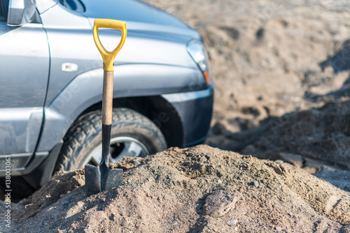 camp shovel on a background of sand stuck in car accident