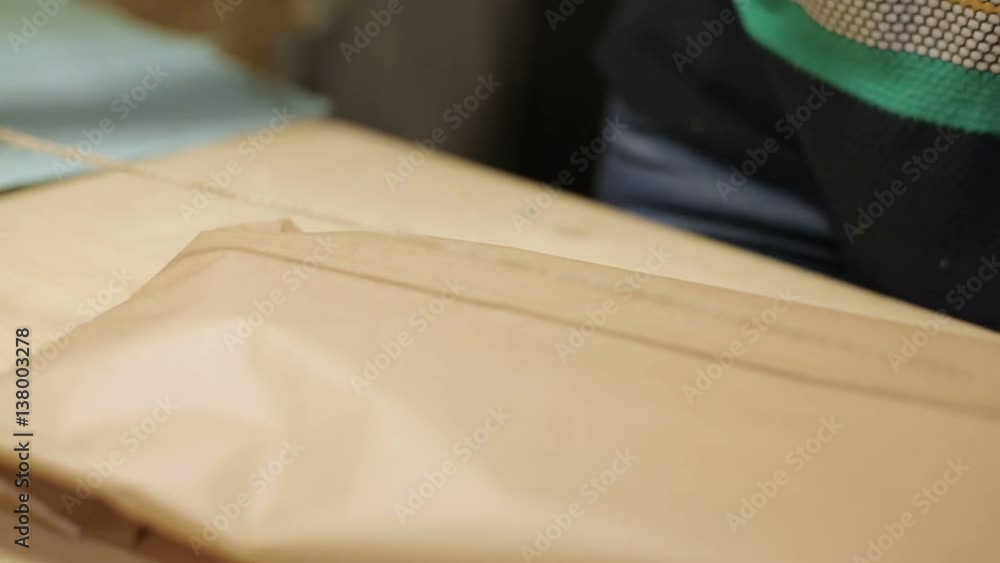 Woman unrecognizable packaging package in craft paper Woman unrecognizable packaging package in craft paper