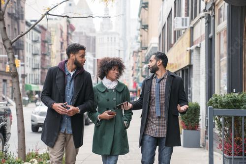People talking while walking on city sidewalk