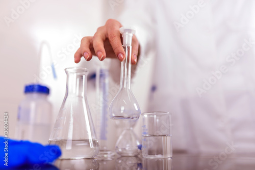 Hand of a Scientist Holds Laboratory Glassware