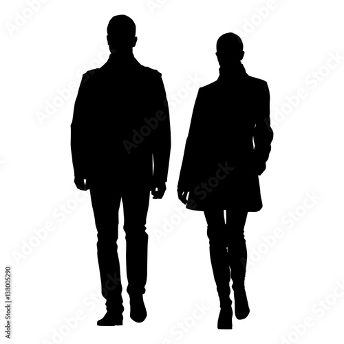 Man and woman walking side by side dressed in coats. Vector silhouette of young couple well dressed people