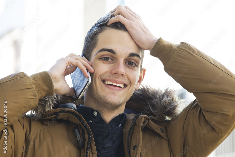 Fototapeta premium young man with the phone on the street talking about