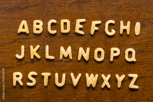 Obraz na płótnie Alphabet made of macaroni letters isolated on wood background w salonie