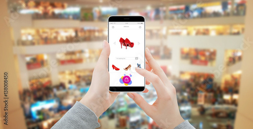 Women hands in shopping mall buying online shoes on modern smartphone
