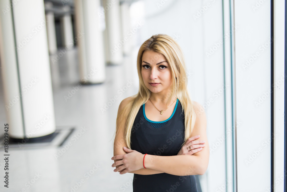 Young woman near big panaramic windows in sport wear before treaining, Young woman near big panaramic windows in sport wear before treaining,