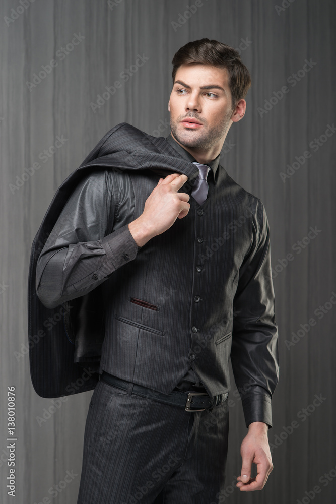 Man model in black waistcoat, trousers, shirt and cravat holding jacket  Stock Photo | Adobe Stock