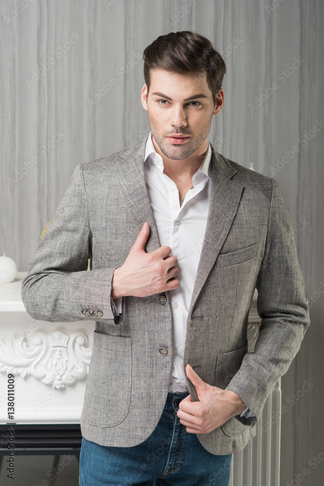 Man model in grey linen jacket white shirt and blue jeans near