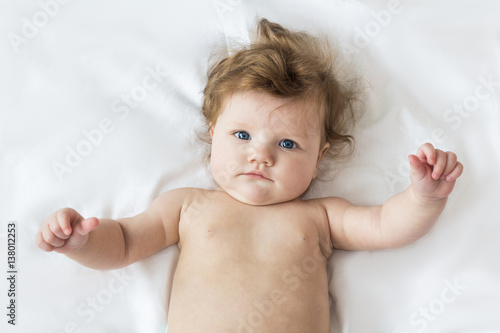 Beautiful little baby lying on a white background.