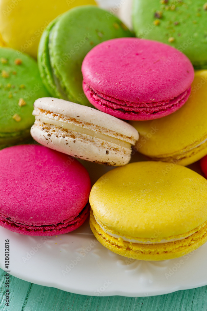 multicolored macaroons on turquoise wooden surface multicolored macaroons on turquoise wooden surface