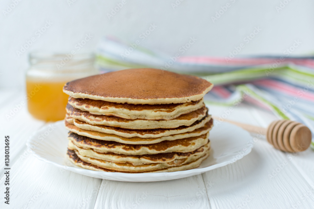 Healthy breakfast. Stack of delicious, homemade pancakes with honey, cherry and banana on white plate Healthy breakfast. Stack of delicious, homemade pancakes with honey, cherry and banana on white plate
