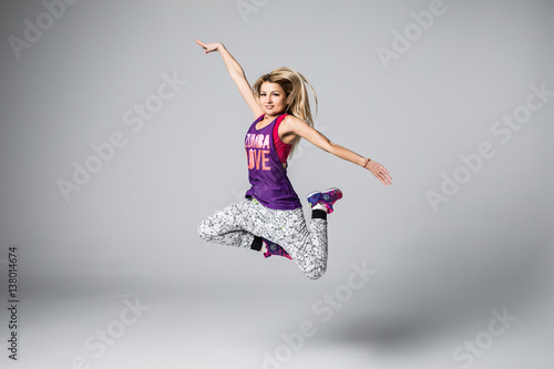Sporty young woman jumping isolated on white background © dianagrytsku