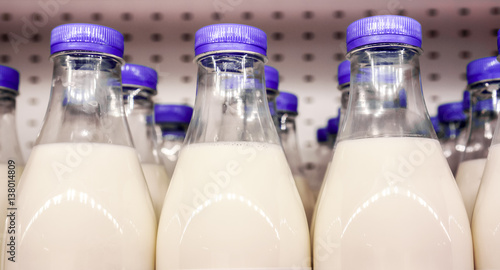bottles with milk as dairy product for preparing breakfast wait for byers on market shelf