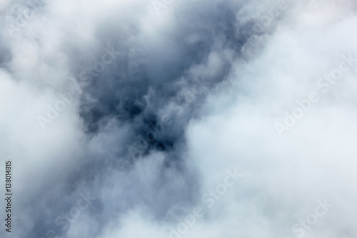 Inside a cloud, view on a cloud from an airplane, photo taken from above a cloud, looking towards a ground.
