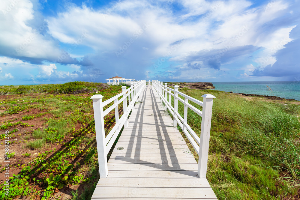 Fototapeta premium Amazing gorgeous beautiful view of a gazebo path leading toward the beach and ocean against magic blue sky background on Cuban Cayo Guillermo Island