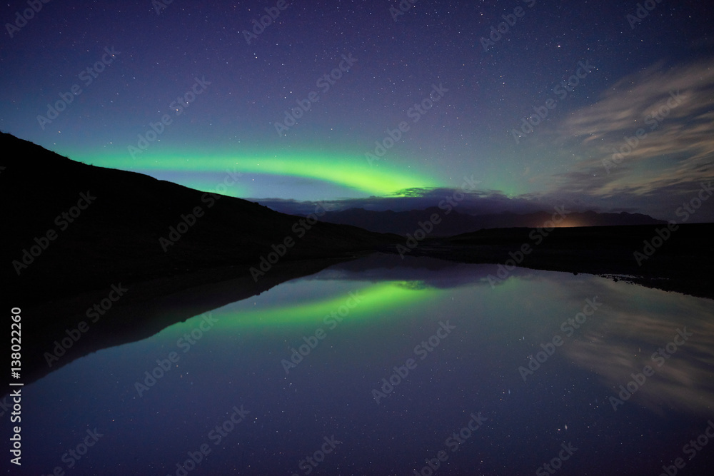 Reflections of aurora borealis over the jokulsarlon lagoon, iceland. image noise due high ISO