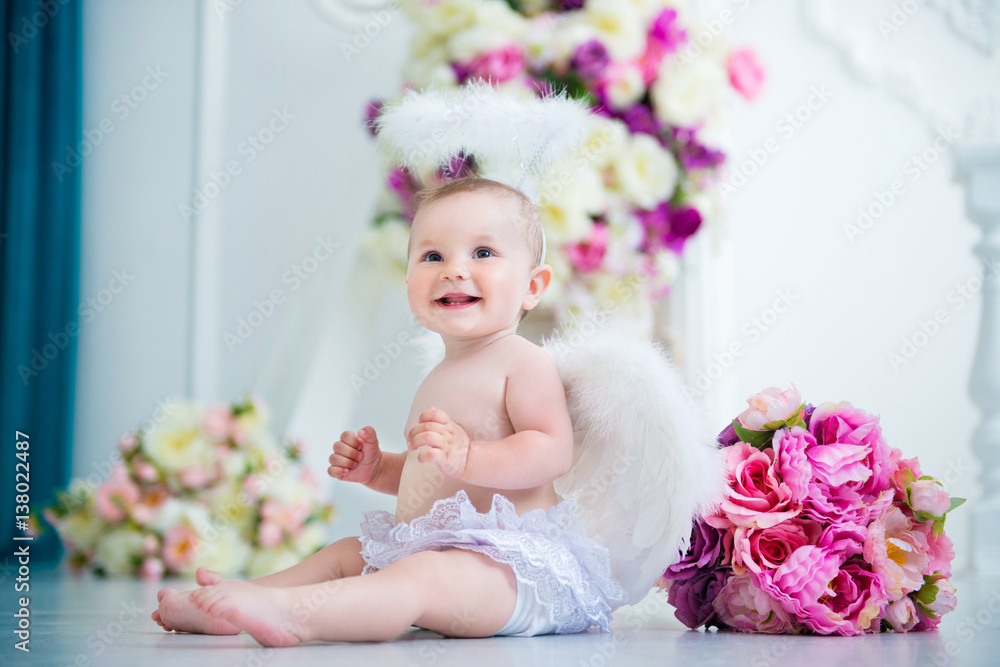 Little angel smiling and happy sitting on the background of flowers and harp Little angel smiling and happy sitting on the background of flowers and harp