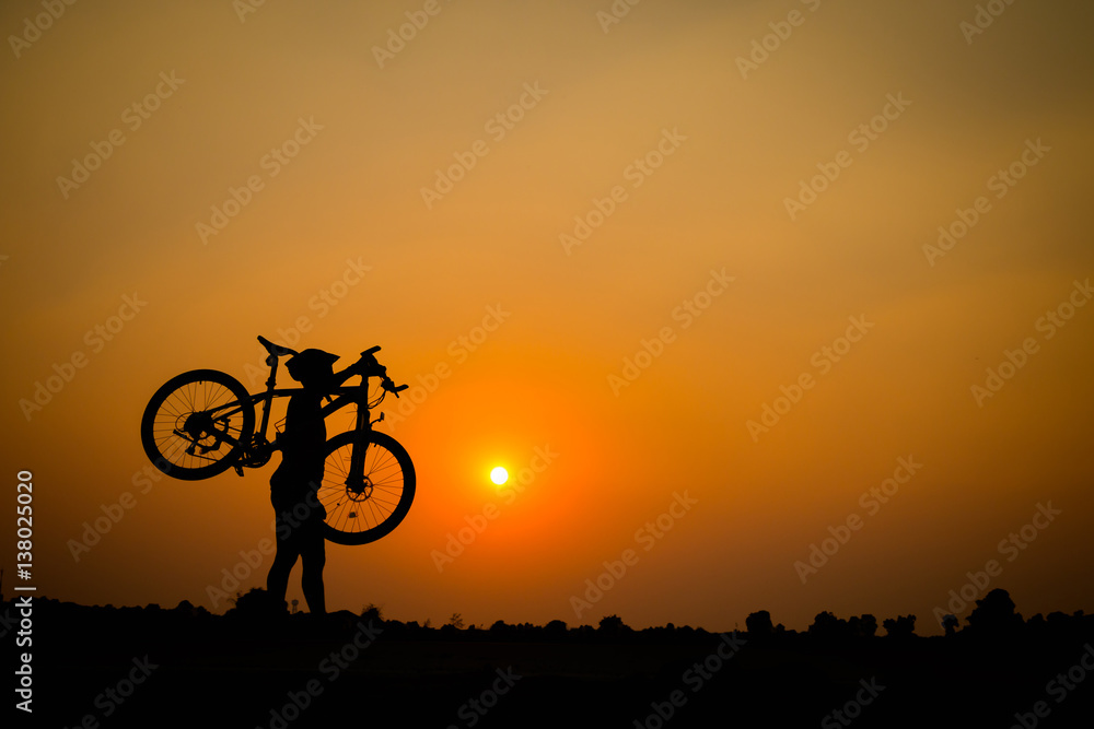 Fototapeta premium Silhouette of young man cyclist on sunset.