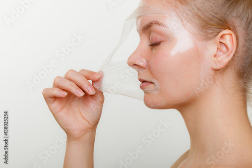 Bilde på lerret Woman removing facial peel off mask.