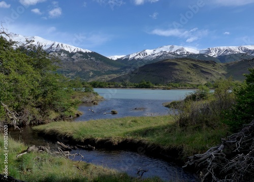 Stream flowing through beautiful grassland surrounded by mountains and into lago paine, Torres del Paine National Park. 