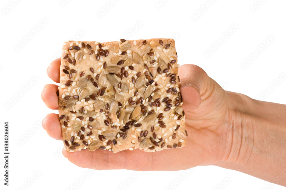 crispy bread with seeds of sunflower, flax and sesame seeds in hand Isolated on white background