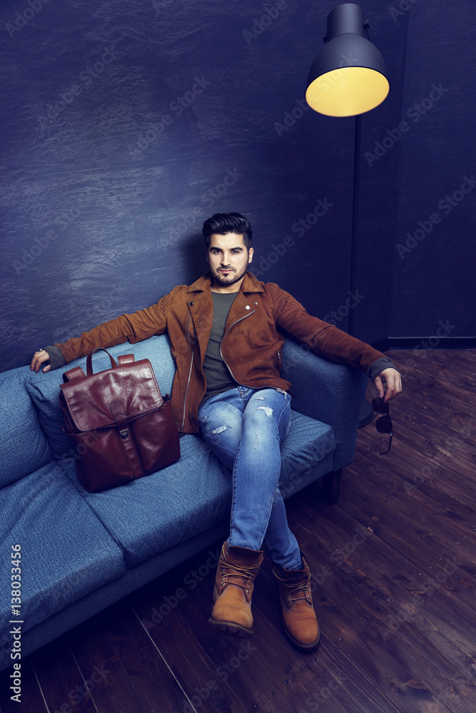 Handsome young man sitting on the sofa. Handsome young man sitting on the sofa.