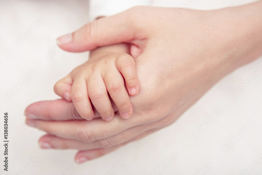 Baby hand gently holding adult's finger (Soft focus and blurry) Baby hand gently holding adult's finger (Soft focus and blurry)
