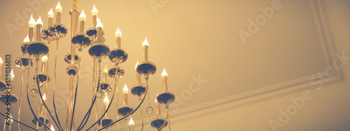 Chandelier with candles under the ceiling.