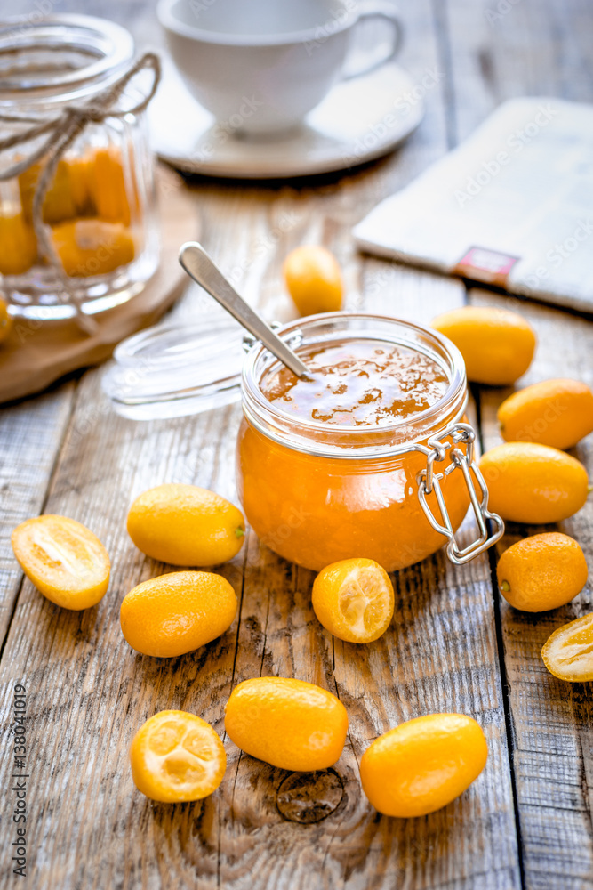 kumquat on plate and jam in jar at wooden table kumquat on plate and jam in jar at wooden table