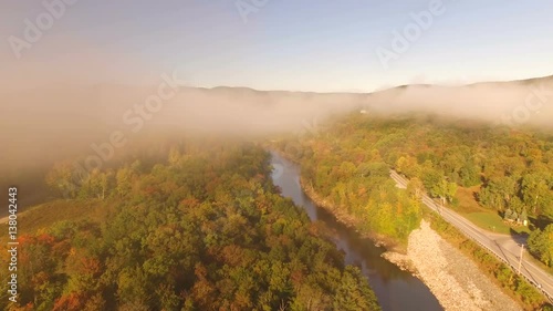 US Countryside Aerial v4 Flying low over Deerfield River through thin morning fog at sunrise. photo