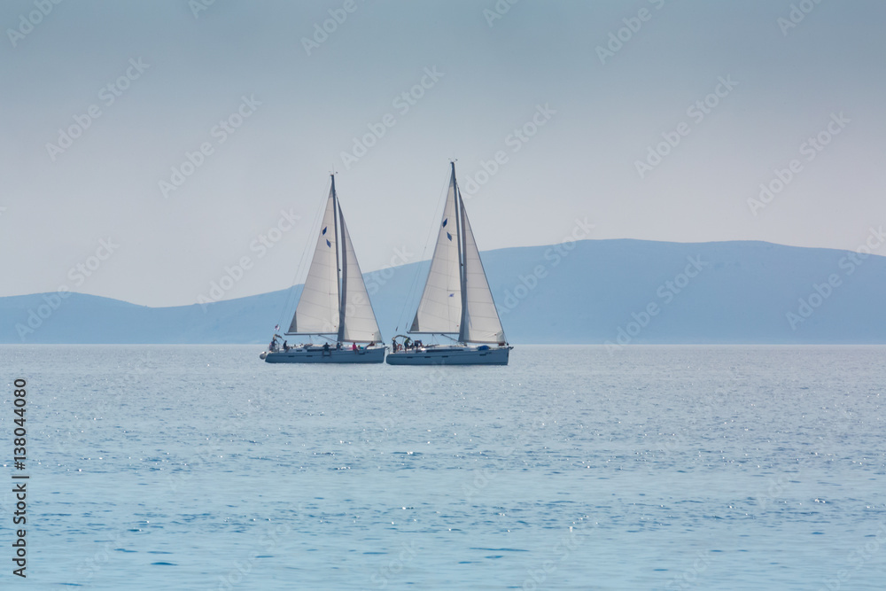 two same yachts sailing on the sea