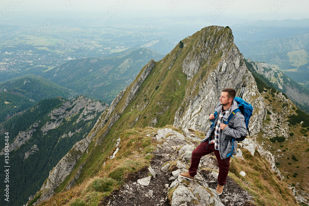 Man standing on a peak while trekking in the mountains