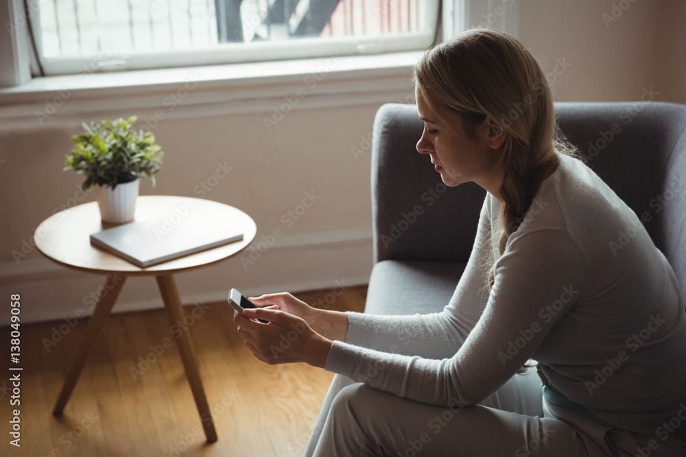 Woman using mobile phone in living room Woman using mobile phone in living room