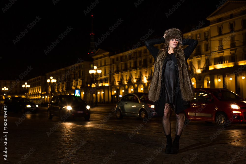 Young woman in the street at night in Torino, Italy