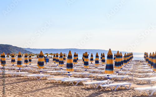The Black Sea shore, blue clear water, beach with sand, umbrellas and sunbeds. Morning. Resort Albena, Bulgaria
