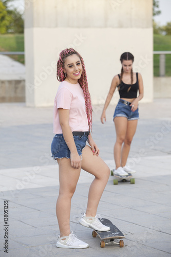 beautiful teen girls having fun and skating with long boards