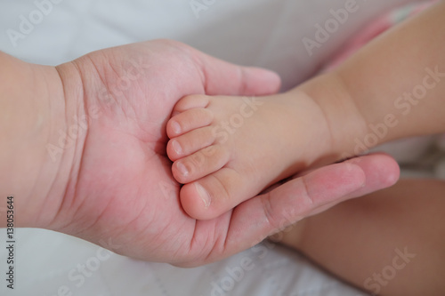 concept of love and family. hands of father and baby closeup.Baby foot in hands