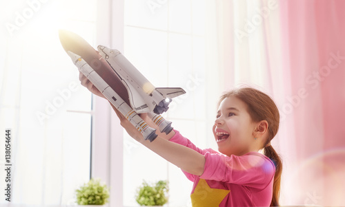 girl playing with toy rocket photo