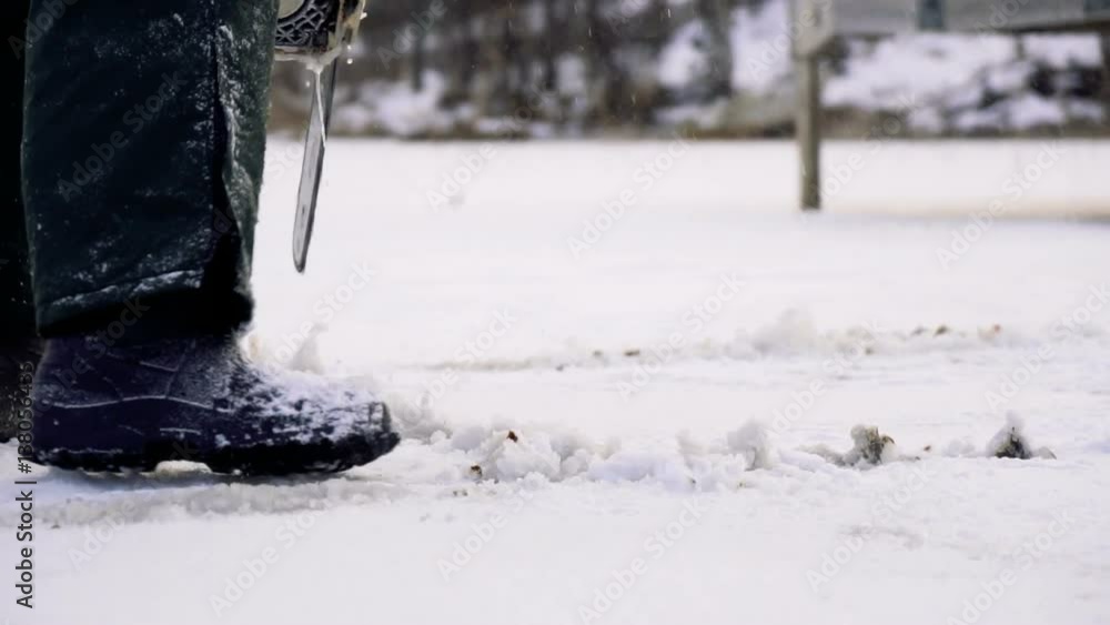 close up view of fisherman hands holding chainsaw which cut ice of frozen lake to make a hole and makes streams of cold water during winter day close up view of fisherman hands holding chainsaw which cut ice of frozen lake to make a hole and makes streams of cold water during winter day