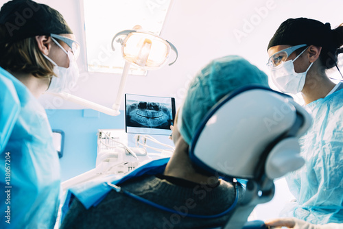 Doctor talking with her patient and teaching a radiograph.