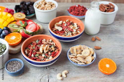 Paleo style nut cereal with fruits and berries on the wooden table, selective focus