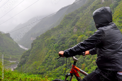 A Man riding bicycle with direction to the waterfalls way at Banos de agua santa, Tungurahua Province, Ecuador