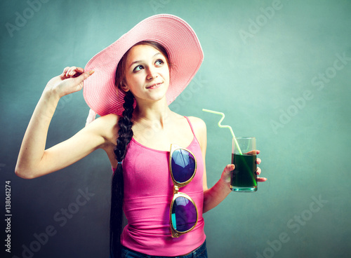 Stylish senior woman drinking cocktail in studio